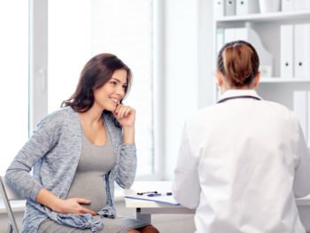 photo of pregnant woman talking to doctor about genetic testing for pregnancy